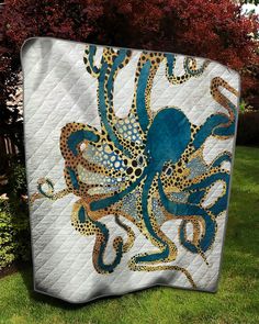 an octopus quilt on the grass with trees in the background