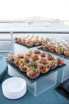 there are many plates and bowls on the table with food in them that is ready to be served