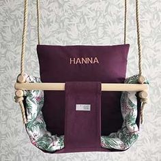 a purple hammock hanging from a rope with the name hannah on it's back