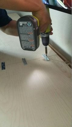 a person using a drill to attach wood planks on a table with screwdrivers