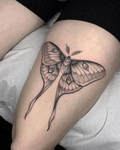 a small butterfly tattoo on the thigh