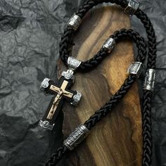 This Christian necklace combines elegance with devotion, featuring an ebony wood cross set against a delicate silk lace. The pendant showcases an Orthodox cross design and is adorned with a prayer, adding a layer of spiritual significance. Accented with a gold crucifix, this religious jewelry piece seamlessly blends tradition with contemporary style, making it a meaningful accessory for those who cherish their faith. FEATURES: -Handmade Craftsmanship: Each piece is meticulously handmade, showcas Luxury Black Cross Pendant Necklace, Black Engraved Crucifix Necklace, Black Crucifix Necklace Engraved, Handmade Black Crucifix Necklace, Elegant Black Crucifix Cross Necklace, Orthodox Cross, Christian Necklace, Wood Cross, Gold Cross Pendant