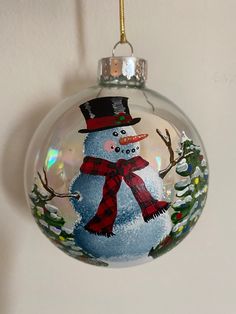 a glass ornament with a snowman on it