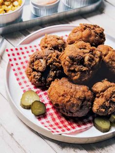 a white plate topped with muffins and pickles on top of a table