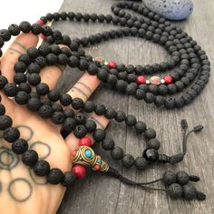 Everyday black lava stone mala necklace. You can choose between 2 styles. 1- A Mala necklace that is all black lava stones which is 43cm- 17 inch long (there is no clasp, you wear it over the head) 2-A Mala necklace which has black lava stones, red beads and unique Nepali beads. This Mala is 48cm- 19 inch long ( there is no clasp, you wear it over your head) This unique unisex mala necklaces can be a diffuser necklaces also, as you can choose which ever oil that you like to use with the lava roc Black Natural Stone Beads For Gift, Black Natural Stones Beads For Gifts, Holistic Black Round Beaded Jewelry, Holistic Black Round Beads Jewelry, Spiritual Black Natural Stone Beads, Handmade Black Mala For Meditation, Black Gemstone Beads Mala For Healing, Handmade Black Mala As Gift, Black Natural Stones Beads For Healing