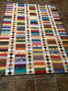 a multicolored patchwork quilt on the floor