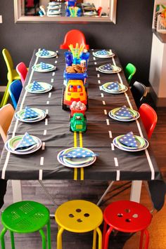 a table set up with colorful plastic chairs and plates for children's birthday party