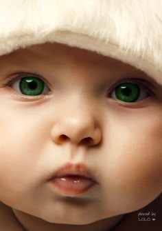 a baby with green eyes wearing a santa hat