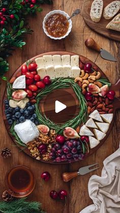 a platter filled with cheese, fruit and nuts on top of a wooden table