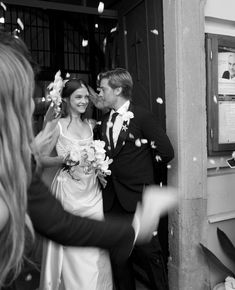 a bride and groom are standing outside with confetti in the air