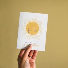 someone holding up a card with the sun on it