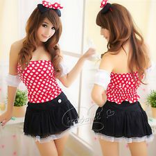 the girl is wearing a red and white polka dot top with black skirt, she has her hands on her hips