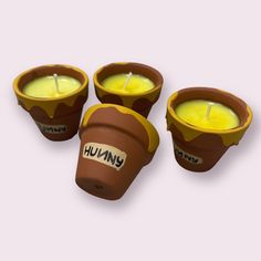 three brown cups with yellow candles in them