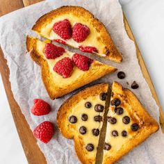 two pieces of toast with raspberries and chocolate chips on top, one slice has been cut in half