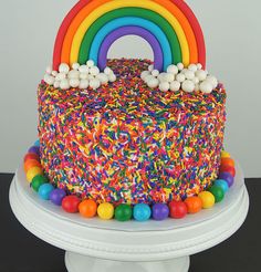 a rainbow cake with sprinkles and candies on top