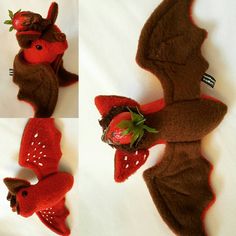 the stuffed animal is made to look like a bat and has strawberries in its mouth