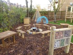 a child's play area with wooden benches and swings