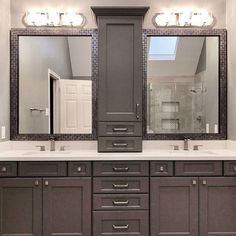 a bathroom with double sinks and two mirrors