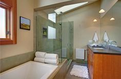 a bathroom with a large bathtub next to a walk in shower