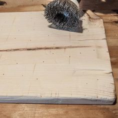 a person using a brush to clean a piece of wood