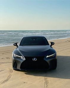 a black car parked on top of a sandy beach