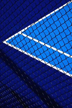 a blue tennis court with white lines on it's side and the net behind it