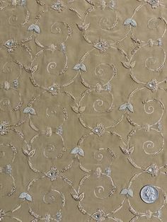 Distinguished by its luxurious design, this high-quality Sand Cream Sequin & Beads on Silk Chiffon JEC-157 Fabric is perfect for women's high-end evening dresses, costumes, jackets, and skirts. Our unique and distinctive fabric is available in a wide selection of colors. The fabric is sold by the Yard, and measures 44 inches in width. Elegant Georgette Fabric With Zari Embroidery, Elegant Festive Embroidered Georgette Fabric, Elegant Embellished Embroidered Fabric For Festive Season, Elegant Embroidered Fabric With Mirror Work For Festive Occasions, Elegant Festive Embroidered Fabric With Mirror Work, Elegant Gold Embroidered Georgette Fabric, Elegant Beige Embroidered Fabric With Zari Work, Elegant Embellished Embroidered Georgette Fabric, Elegant Beige Embroidered Fabric For Festive Occasions