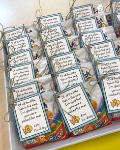 a table topped with lots of candy bags filled with cards and string wrapped in twine