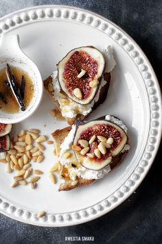 a white plate topped with toast covered in fruit and nuts