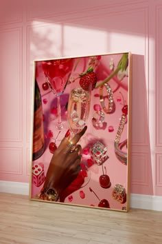 a woman's hand is holding a wine glass in front of a pink wall