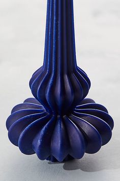 a blue vase sitting on top of a white table