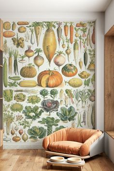 an orange chair sitting in front of a wall with vegetables on it