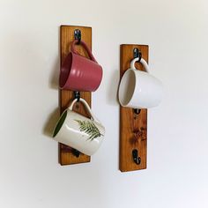 two mugs are hanging on the wall next to each other