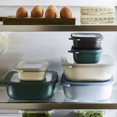 several containers with food in them are sitting on the shelf next to an egg carton