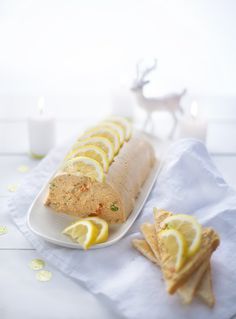 a white plate topped with a sandwich and slices of lemon next to a deer figurine