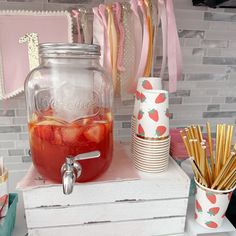 strawberries in a mason jar sitting on top of a white dresser next to other items