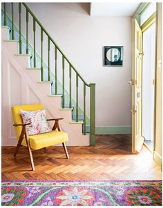 a yellow chair sitting in front of a stair case