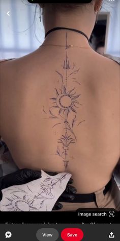 the back of a woman's neck with tattoos on it and an image search button