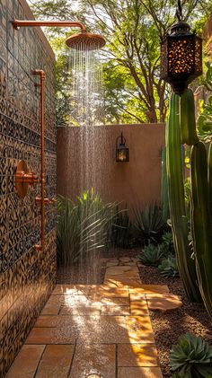 An outdoor shower with a copper showerhead, warm terracotta tile walls, and desert-inspired landscaping, including cacti and succulents, water glistening under a golden glow, Moroccan lanterns casting intricate patterns, and a serene oasis vibe in an arid desert environment Water Glistening, Modern Mediterranean Bathroom, Desert Spa, Moroccan Spa, Outdoor Shower Inspiration, Spa Vibes, Tile Walls