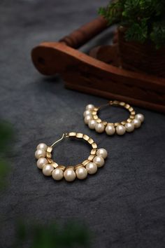 Pearl Hoops/Hoop Earrings For Women & Girls Material : Glass, faux pearl, resin, and metal Dimension : 2 x 1.5 inches approx. Don't wait, grab these pearl hoop earrings before they're gone! Gold synthetic beads are threaded in a metal hoop, and pearls are set along the edges to give it an ethereal look. These lightweight earrings are the perfect addition to your ethnic attire. Closure type: Ear Wire  Finish: Antique gold Note: This is a handcrafted product that might have slight variations or ir Hoop Pearl Earrings For Party, Pearl Hoop Earrings For Party, Festive Round Metal Pearl Earrings, Golden Earring, Pearl Resin, Golden Earrings, Earring For Women, Jewelry Statement, Pearl Hoop Earrings