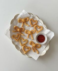 some heart shaped pretzels on a plate with ketchup