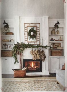 a living room filled with furniture and a fire place covered in christmas stockings next to a fireplace