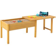 a wooden table with sand and toys on it