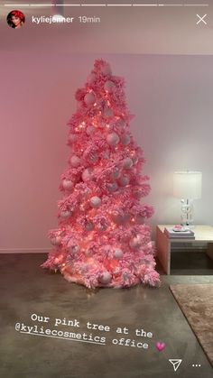 a pink christmas tree with ornaments on it