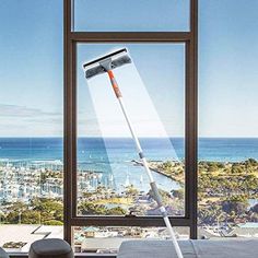 a window that has a mop on it in front of a bed with a view of the ocean