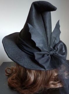 a woman's head wearing a black hat with a large bow on the top