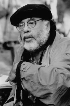 black and white photograph of an old man with glasses, wearing a hat and jacket