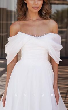 a woman in a white dress posing for the camera with her hands on her hips