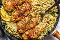 chicken and rice in a skillet with spoons on the side, ready to be eaten