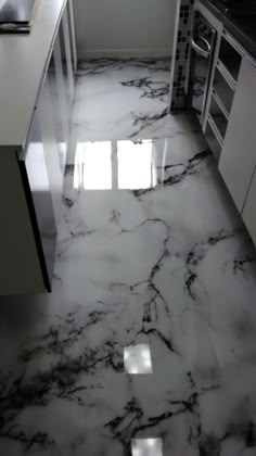 a kitchen with marble floors and white cabinets